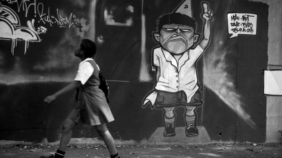 On the Move, a schoolgirl walking past graffiti in Cape Town, by Martin Osner