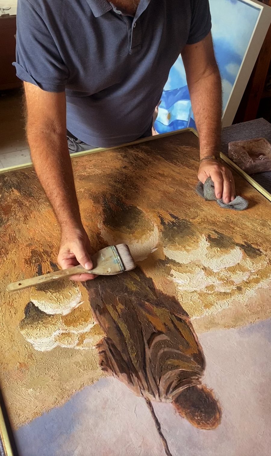 Martin Osner working into the surface of Eternal Shepherd with a brush and cloth